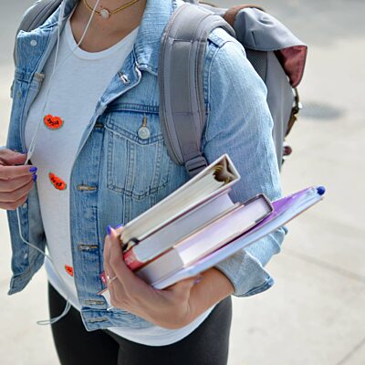 Student has books under her arm.